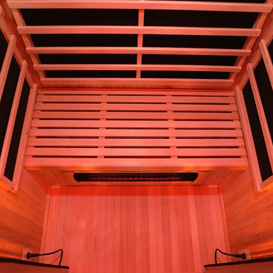Infrared sauna with wooden interior and glowing red light.